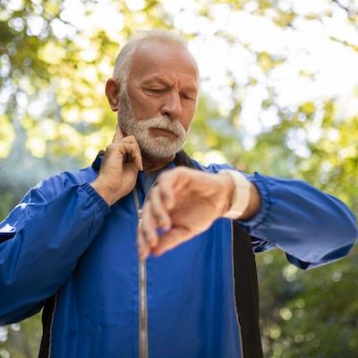 Älterer Mann überprüft seine Smartwatch beim Sport im Freien, symbolisch für Herz-Kreislauf-Gesundheit und medizinische Labordiagnostik zur Analyse von Risikofaktoren wie Cholesterin, Entzündungswerten und Stoffwechselparametern.