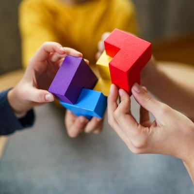 Hände setzen bunte Bausteine zusammen, symbolisch für einen individuell konfigurierbaren Gesundheitscheck und medizinische Labordiagnostik mit frei wählbaren Blutwerten und Laboranalysen.